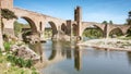 The medieval bridge of BesalÃÂº, Girona, is reflected on a river